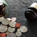 Money spilling out of a jar next to a gavel_s