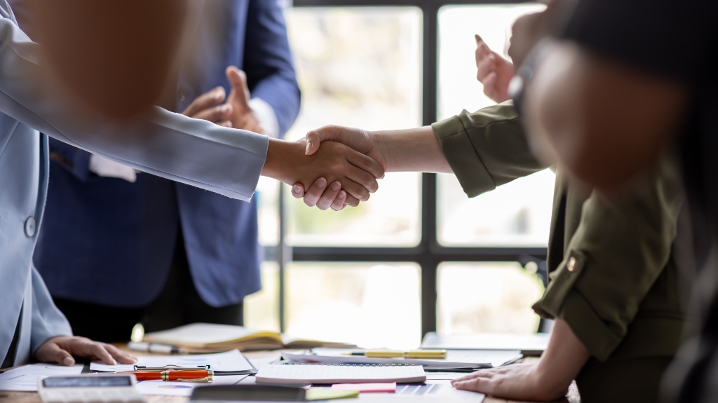 Business Team offer and give hand for handshake in office