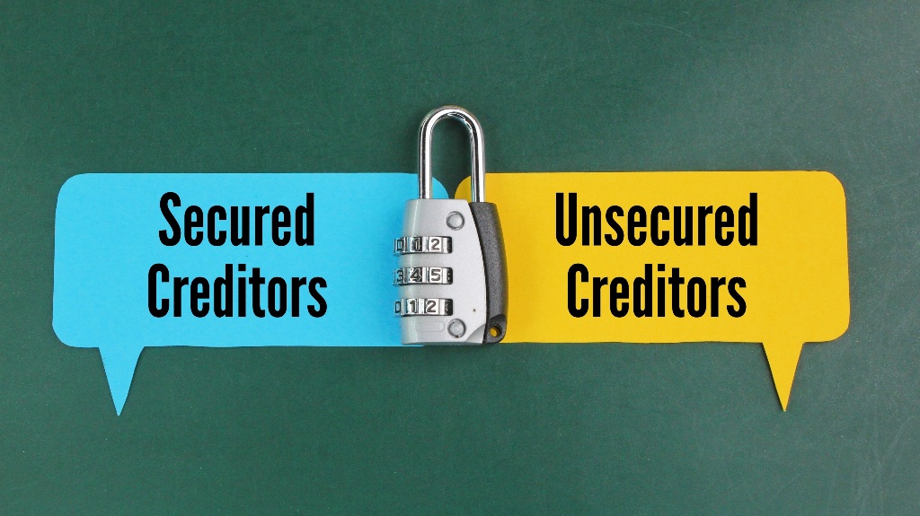 keys and colored paper with the words secured creditors and unsecured creditors