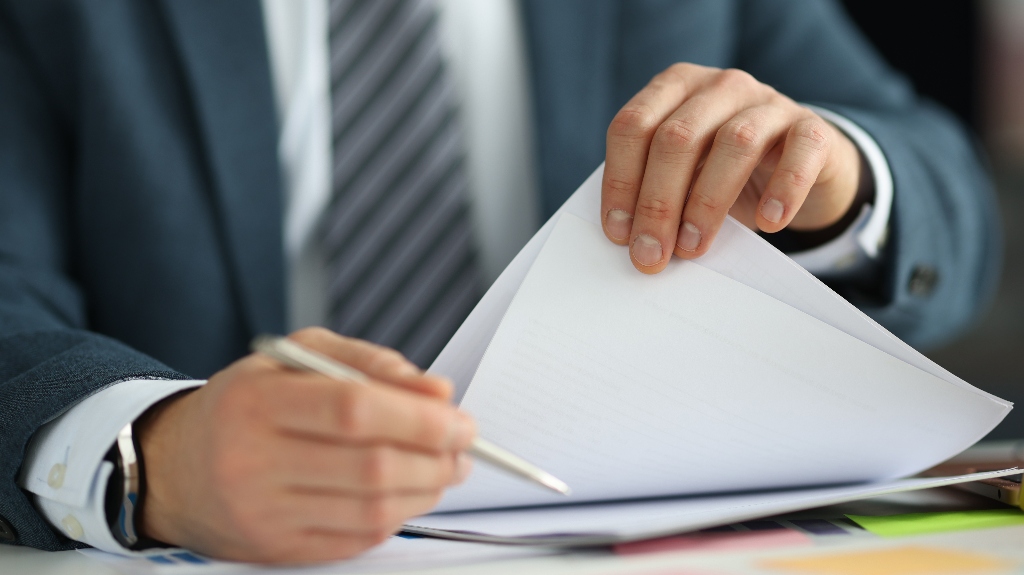 man in suit holding documents in his hands