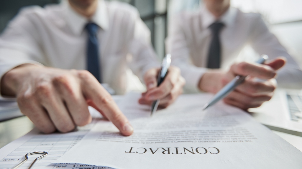 Man is pointing a finger at one clause in a contract