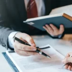 Lawyer is showing client where to sign document_s